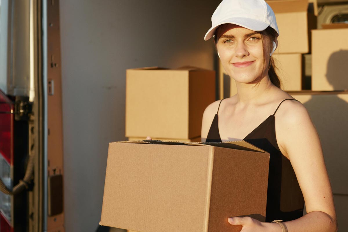 LambertSummerMoving1200px) Girl carrying moving boxes